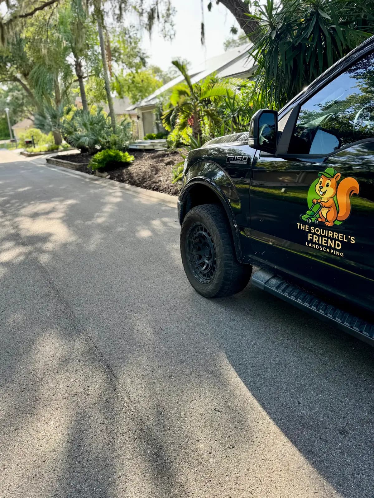 The The Squirrel's Friend Landscaping truck parked on a client driveway