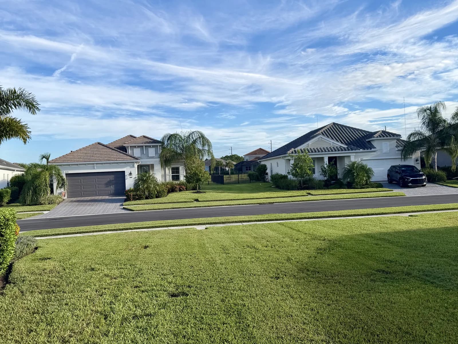 A wide striped front lawn under a blue sky