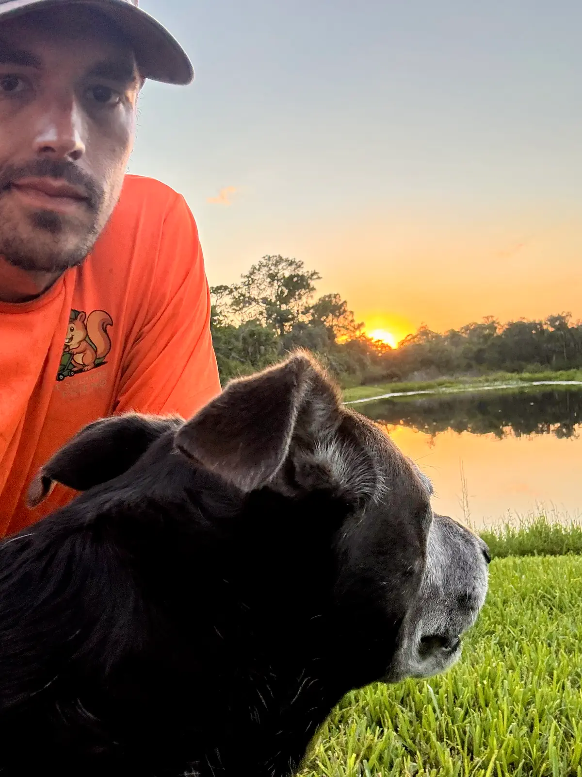 Alex Bolduc, owner of The Squirrel's Friend Landscaping, with his dog at sunset